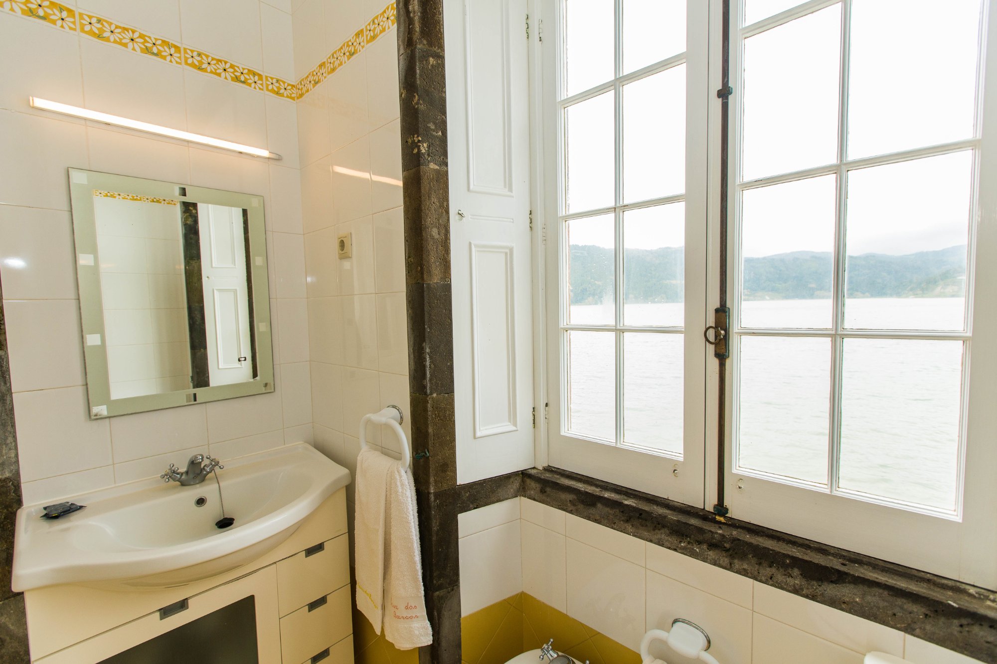 En-suite bathroom with lake view through original stone window